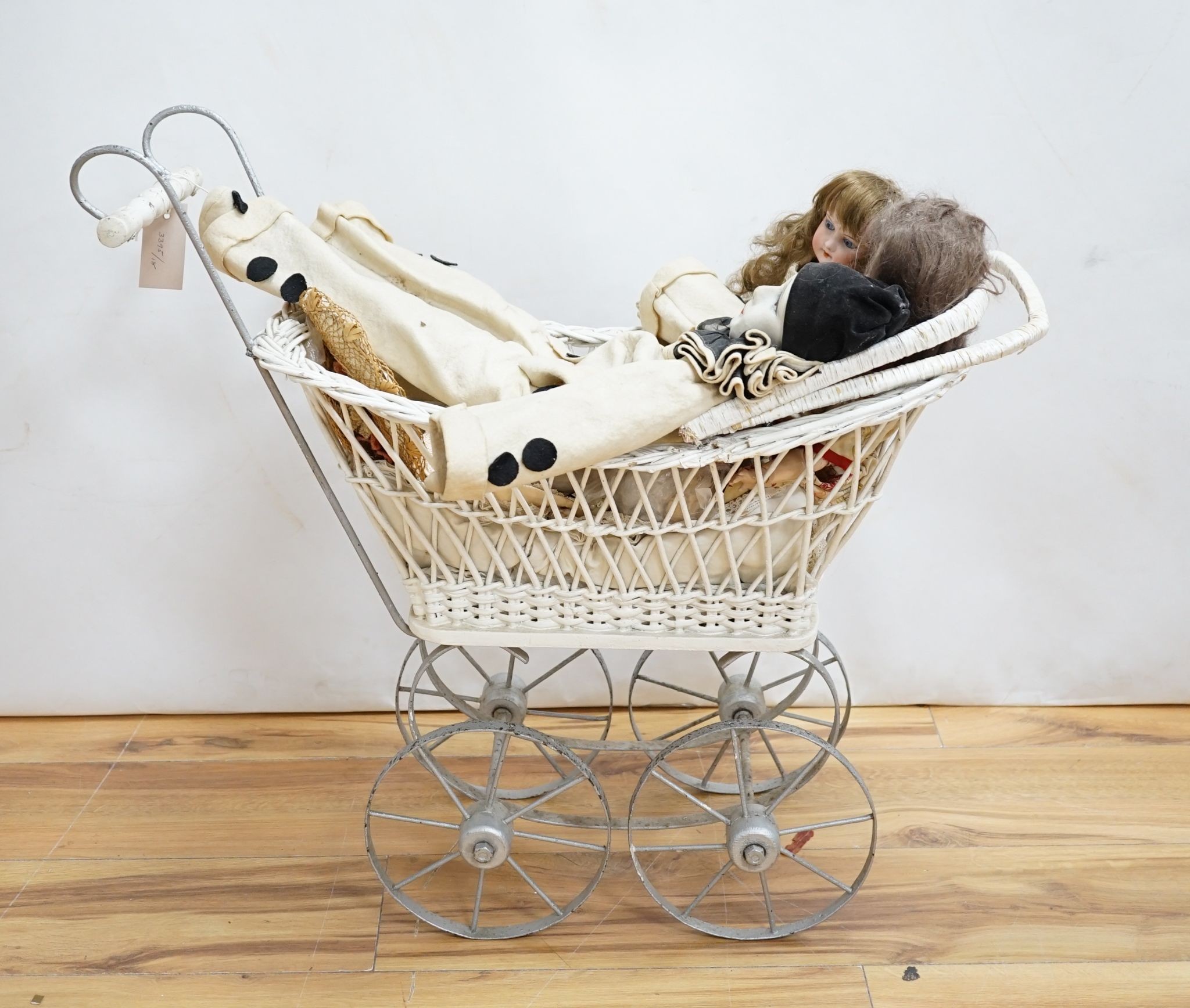 Two Armand Marseille 390 bisque dolls, largest 40cm., Lenci-type cloth doll, painted wicker pram and a child's rush seated elbow chair